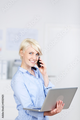 Photo: lächelnde frau mit laptop und telefon lächelnde frau mit laptop und telefon