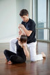 Instructor Helping Woman In Yoga Exercise