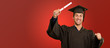 Young Man In Graduation Gown Holding Certificate