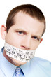 Photo: Isolated man with tape measure around mouth Isolated man with tape measure around mouth