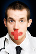Photo: Silent handsome doctor with cross bandage on face Silent handsome doctor with cross bandage on face