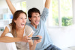 Young couple playing video games at home