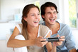 Young couple playing video games at home