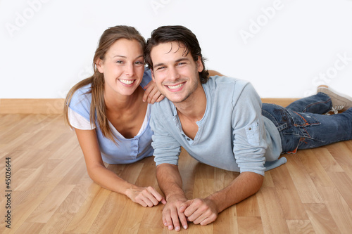 Photo: Cheerful couple laying down wooden floor Cheerful couple laying down wooden floor