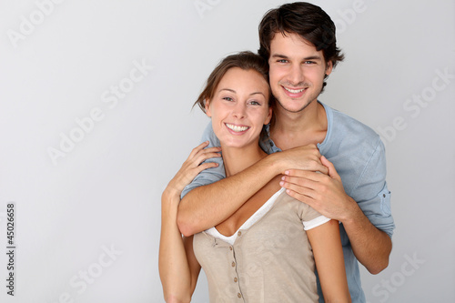 Photo: Cheerful young couple standing on white background, isolated Cheerful young couple standing on white background, isolated