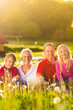 Glückliche Familie sitzt auf Sommer Wiese