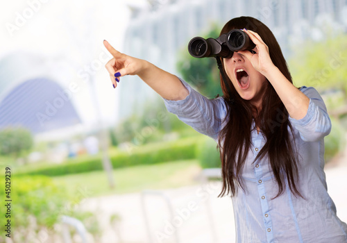 Photo: Portrait Of A Young Woman Looking Through Binoculars Portrait Of A Young Woman Looking Through Binoculars