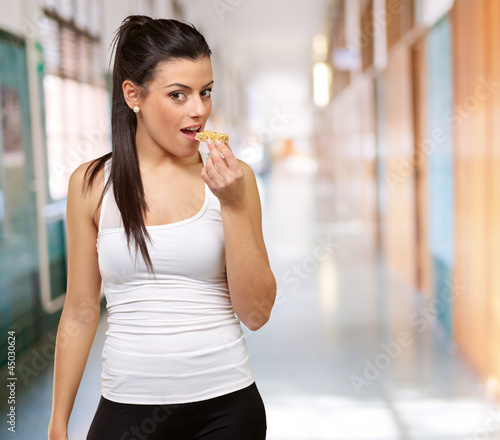 Photo: A young woman eating a granola bar A young woman eating a granola bar