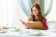 A woman in a restaurant with the menu in hands