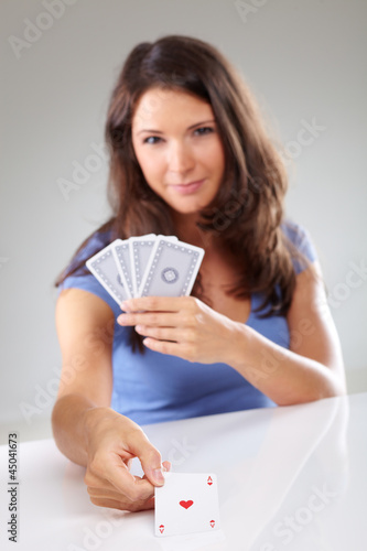 Photo: Woman with playing cards, focus on ace of hearts Woman with playing cards, focus on ace of hearts