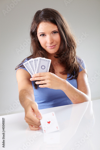 Photo: Woman playing cards with ace of hearts in her hand Woman playing cards with ace of hearts in her hand