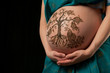 Henna tree of life design on a woman's pregnant belly
