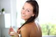 Gorgeous woman putting conditioner in her hair