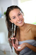 Gorgeous woman putting conditioner in her hair
