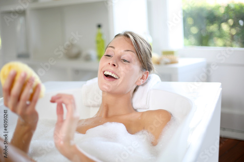 Photo: Beautiful woman using bath sponge Beautiful woman using bath sponge
