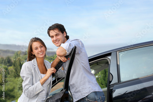 Photo: Young couple on a week-end trip in car Young couple on a week-end trip in car