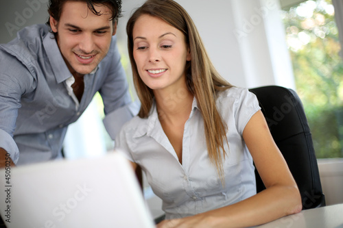Photo: Business team working on laptop computer Business team working on laptop computer