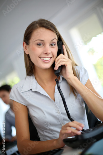 Photo: Beautiful office worker talking on the phone Beautiful office worker talking on the phone