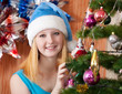 Girl in christmas hat near spruce