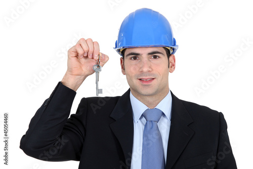 Photo: Engineer holding up a key Engineer holding up a key