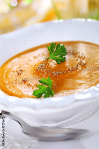 Photo: Pumpkin soup with orange juice in white plate, soft focus. Pumpkin soup with orange juice in white plate, soft focus.