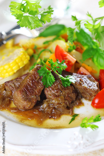 Photo: Beef stew with vegetables and salad of fresh tomato. Beef stew with vegetables and salad of fresh tomato.