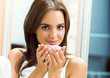 Young woman drinking coffee or tea, at home