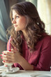 A woman in a restaurant is drinking coffee