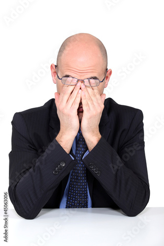 Photo: Tired man rubbing his eyes Tired man rubbing his eyes
