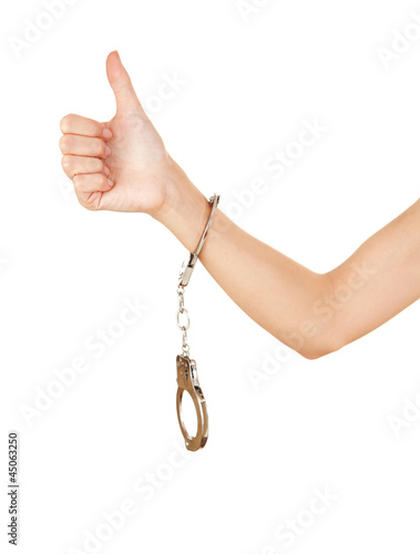 Photo: woman hand with handcuffs and thumb up woman hand with handcuffs and thumb up