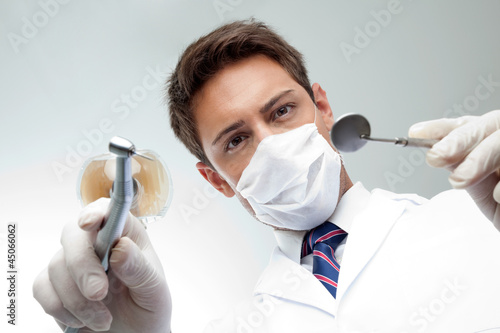Photo: Dentist Holding Angled Mirror And Drill Dentist Holding Angled Mirror And Drill