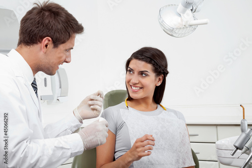 Photo: Dentist Holding Thread While Patient Looking At Him Dentist Holding Thread While Patient Looking At Him