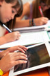 Girls hands on tablet at homework session.