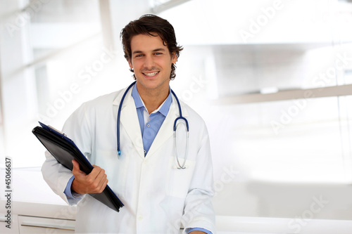 Photo: Cheerful student in medicine standing in hospital hallway Cheerful student in medicine standing in hospital hallway