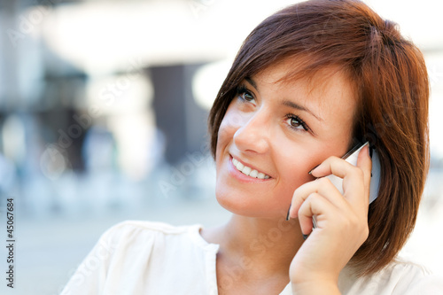 Photo: Beautiful woman speaking on the phone outdoor Beautiful woman speaking on the phone outdoor