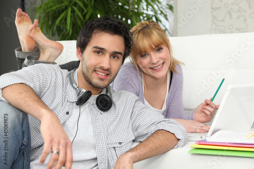 Photo: Couple at home with laptop and headphones Couple at home with laptop and headphones