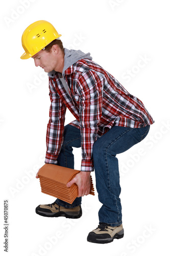 Photo: Tradesman lifting shingles Tradesman lifting shingles