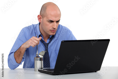 Photo: Businessman eating out of tin can Businessman eating out of tin can