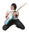 "Young man kneeling and playing electric guitar, studio shot"