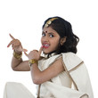 Photo: "Girl (8-9) wearing traditional sari performing figures from indian traditional dance, studio shot" "Girl (8-9) wearing traditional sari performing figures from indian traditional dance, studio shot"