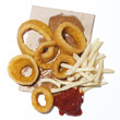 "Onion rings and french fries with ketchup on paper bag, view from above, studio shot"