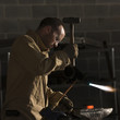 "USA, Utah, Orem, man welding with hammer and blowtorch in workshop"