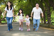 happy asian family walking on the road