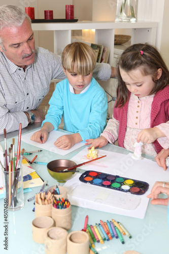 Photo: Man watching grandchildren paint Man watching grandchildren paint