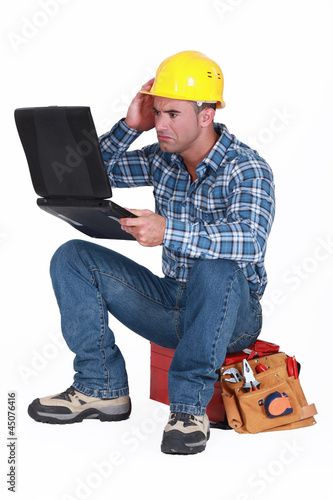 Photo: Confused builder sat with laptop Confused builder sat with laptop