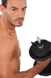 bare-chested man muscular man doing fitness with dumbbell
