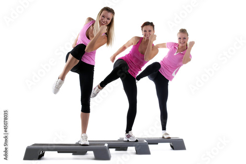Photo: young group women training on stepper isolated young group women training on stepper isolated