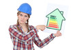 Stern tradeswoman giving an energy efficiency rating of G