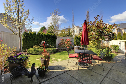 Photo: Spring house back yard with red chairs and umbrella Spring house back yard with red chairs and umbrella