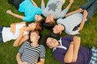 Six teenage friends lying on the grass and having fun